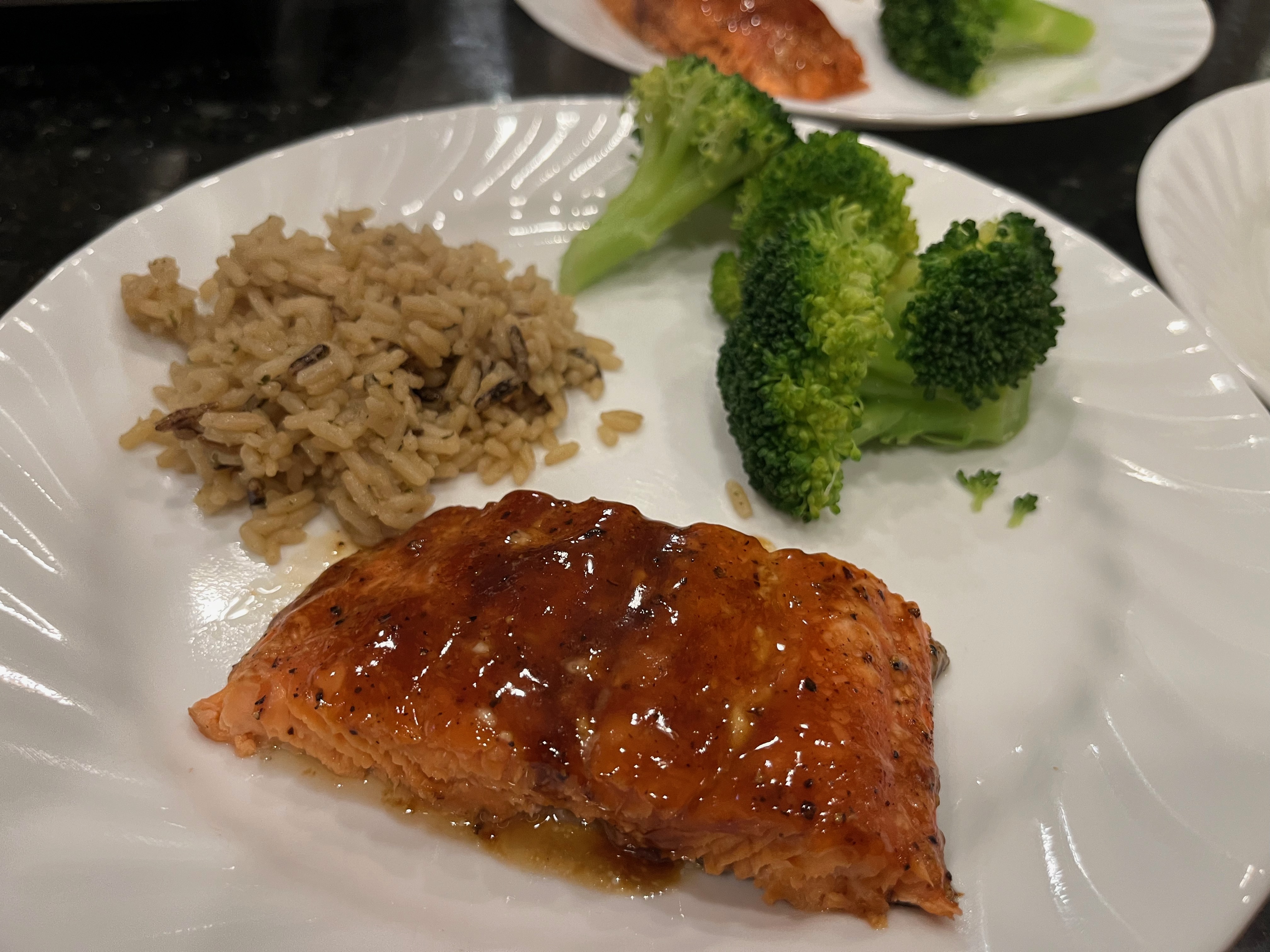 A plate with salmon, steamed brocoli, and rice